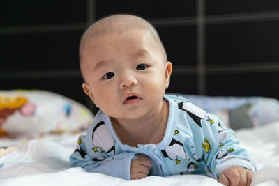 Portrait of cute baby lying on bed