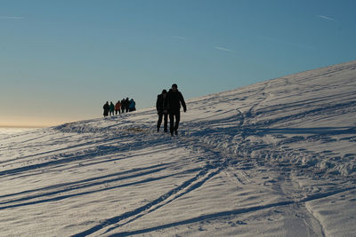 Winter snow walking under the setting sun at sunset on the wasserkuppe mountain in hesse germany