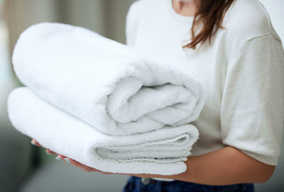 Midsection of woman with towels at home
