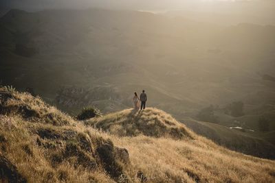 People on field against mountain range