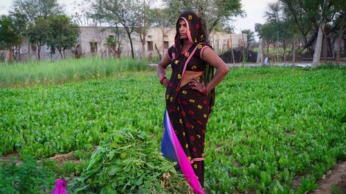 Serious young indian woman looking into the distance near a field. beautiful woman stands in a green