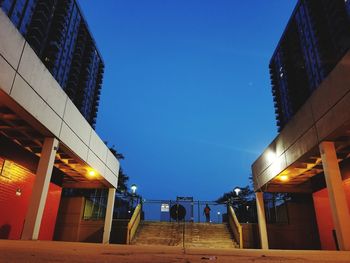 Low angle view of illuminated buildings against blue sky