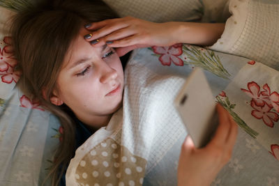 Tired female lying in bed, surfing in web, chat and flirting. woman can't fell asleep. 