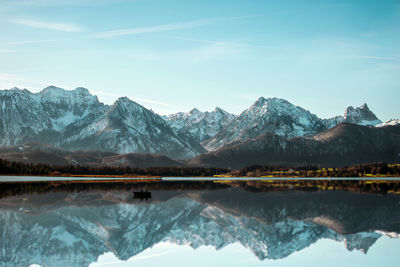 Scenic view of lake and snowcapped mountains against sky