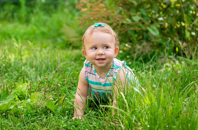 Cute baby girl crawling on grass