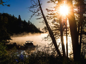 Scenic view of lake against foggy sunrise