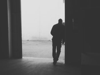 Silhouette man standing in corridor of building