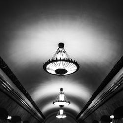 Low angle view of illuminated pendant lights hanging from ceiling in building