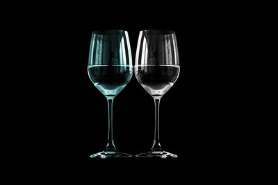 Wine in glasses against black background