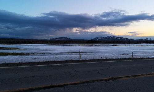 Scenic view of lake by snowcapped mountains against sky