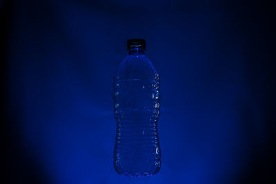 Close-up of glass bottle against blue background