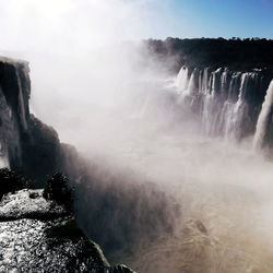 Scenic view of waterfall against sky