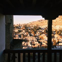 Buildings against sky seen through window