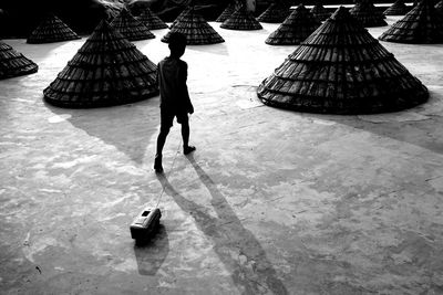 Rear view of boy playing with toy car on footpath