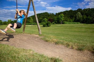 Woman sitting on swing at playground