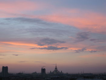 Silhouette of buildings against cloudy sky during sunset