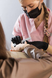 Beautician doing manicure at spa