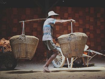 Full length of worker carrying baskets
