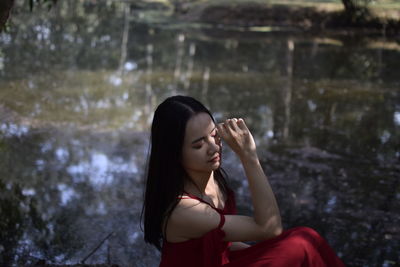 Woman sitting by lake