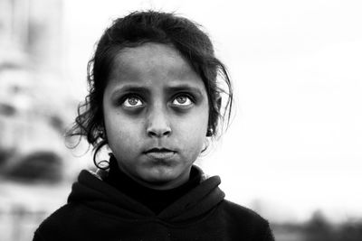 Close-up of girl looking up against sky