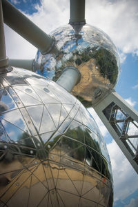 Low angle view of glass structure against sky