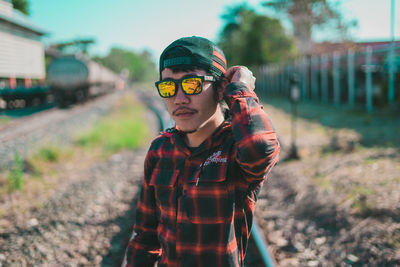 Portrait of man wearing sunglasses standing outdoors