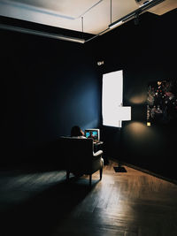Man sitting on table in illuminated room