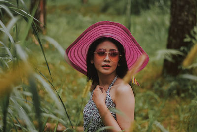 Portrait of beautiful young woman standing on land