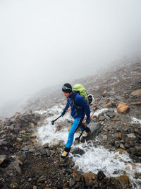 Full length of woman climbing rock formation