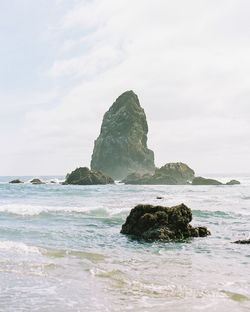 Rock formation on beach against sky