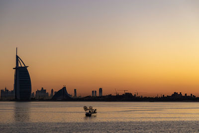 Silhouette of boats in river during sunset