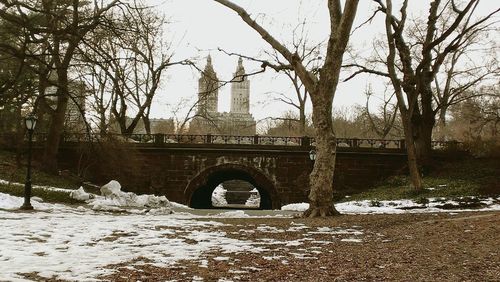 Bridge over canal against sky during winter