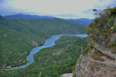 Scenic view of river amidst mountains against sky