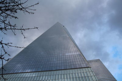 Low angle view of modern building against cloudy sky