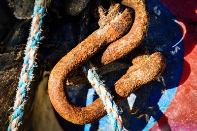 Close-up of rope tied on rusty chain