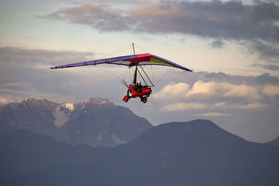 Man flying glider against mountains