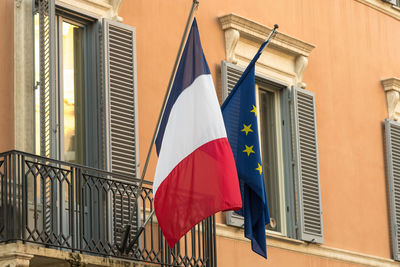 Low angle view of french and european union flags against a building