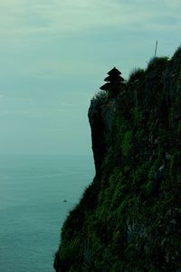 Scenic view of sea by cliff against sky