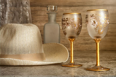 Still life of two empty glass of wine with wine bottle and white hat