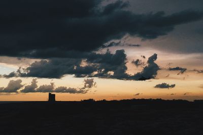 Silhouette landscape against sky during sunset