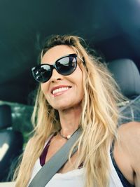 Portrait of smiling woman with blond hair sitting in car