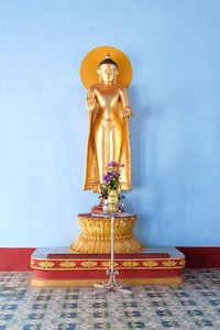 Statue of buddha against wall in building