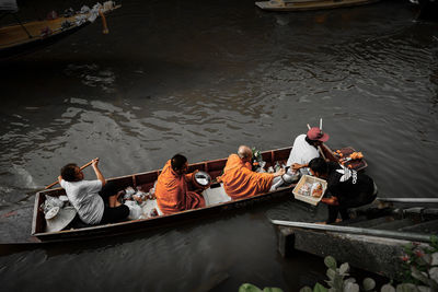 High angle view of people sitting on boat in lake