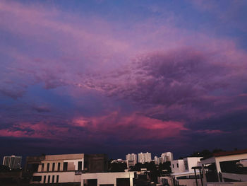 Low angle view of buildings against dramatic sky