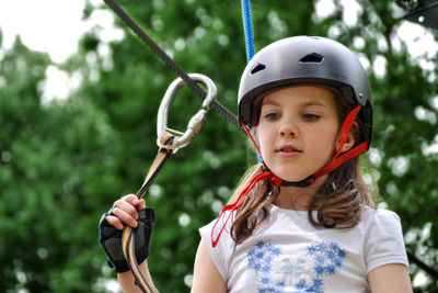 Adventure climbing high wire park - people on course in mountain helmet and safety equipment.