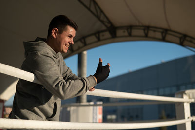 Caucasian male boxer resting in the ring outdoors