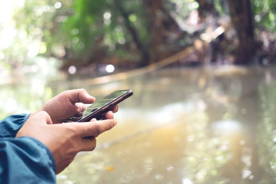 Midsection of man using mobile phone