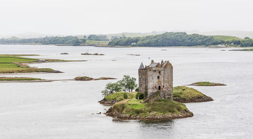 Historic building by sea against sky