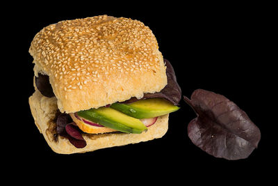 Close-up of burger against black background