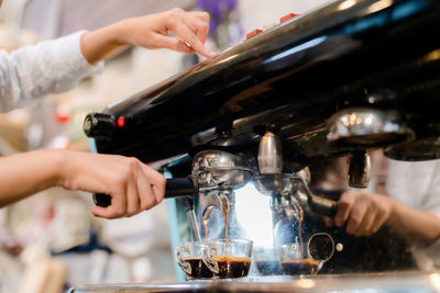 Cropped image of person pouring coffee in glass